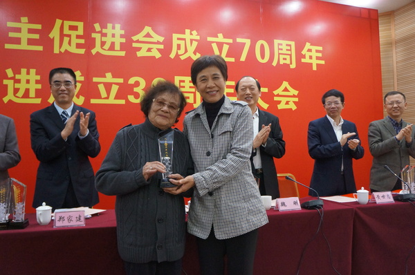 廈門市統(tǒng)戰(zhàn)部部長黃菱給入會60周年97歲高齡的民進(jìn)會員謝植桂頒發(fā)榮譽(yù)獎杯。