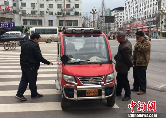 營山城區電動四輪車司機正在討論車輛的車況。　劉忠俊 攝