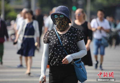 資料圖：5月17日，北京街頭的民眾防曬出行。當日北京市氣象臺發布今年首個高溫黃色預警。<a target='_blank' href='http://www.chinanews.com/'>中新社</a>記者 楊可佳 攝