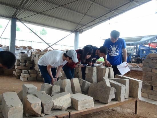 圖7 中國(guó)人民大學(xué)研究生在曹魏大墓工地現(xiàn)場(chǎng)考察出土墓磚（李重蓉?cái)z影）