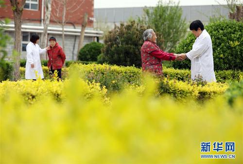 5月5日，在河北省衡水市桃城區(qū)一家養(yǎng)老康復(fù)醫(yī)療中心，護(hù)工在陪老人散步。新華社記者 牟宇 攝